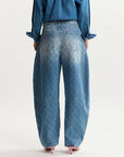 Person wearing blue jeans and a matching top on a white background