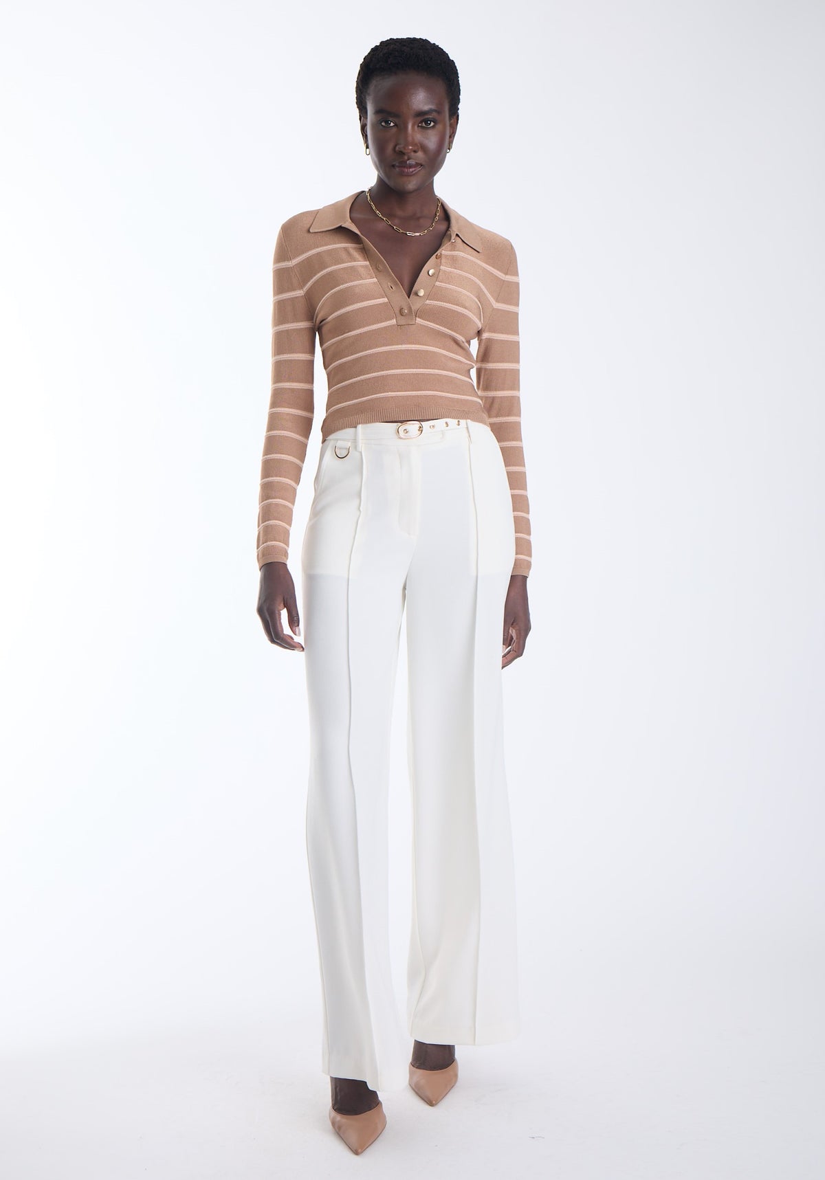 model wearing a tan long sleeve polo with light pink small stripes and white pants on a white background 