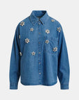 Blue denim shirt with floral embellishments on a white background