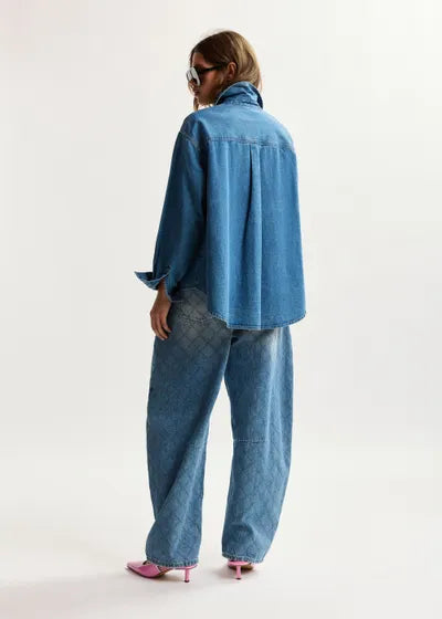 Person wearing a blue denim outfit on a white background