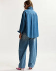 Person wearing a blue denim outfit on a white background