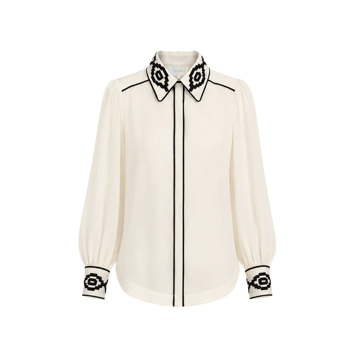 An off-white long-sleeve blouse with black embroidered geometric patterns on the pointed collar, cuffs, and down the center front placket, shown against a plain white background.