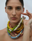 Woman wearing a colorful beaded necklace against a plain background