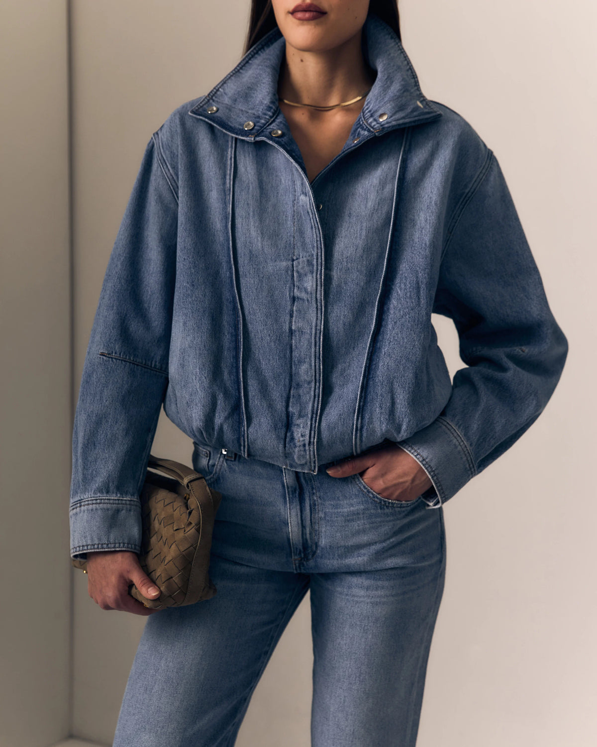 model wearing a denim jacket with jeans on a cream background 