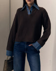 model wearing the harvey sweater that is a brown ribbed sweater with denim collar and cuff trim with jeans on a cream background 