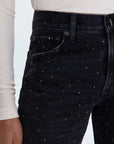 Black jeans with rhinestone embellishments worn by a person on a light gray background