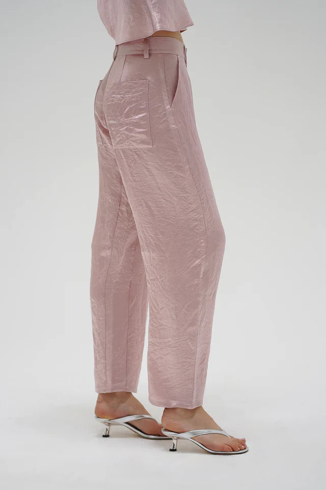 Person wearing pink pants and a matching top on a white background