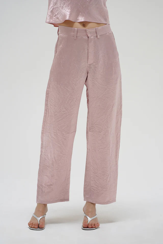 Pink pants worn by a person on a white background