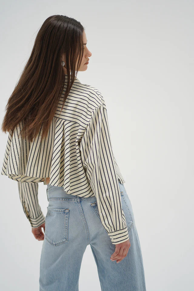 Woman wearing a striped shirt and jeans on a white background back view