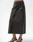 model wearing a brown wrap skirt on a white background