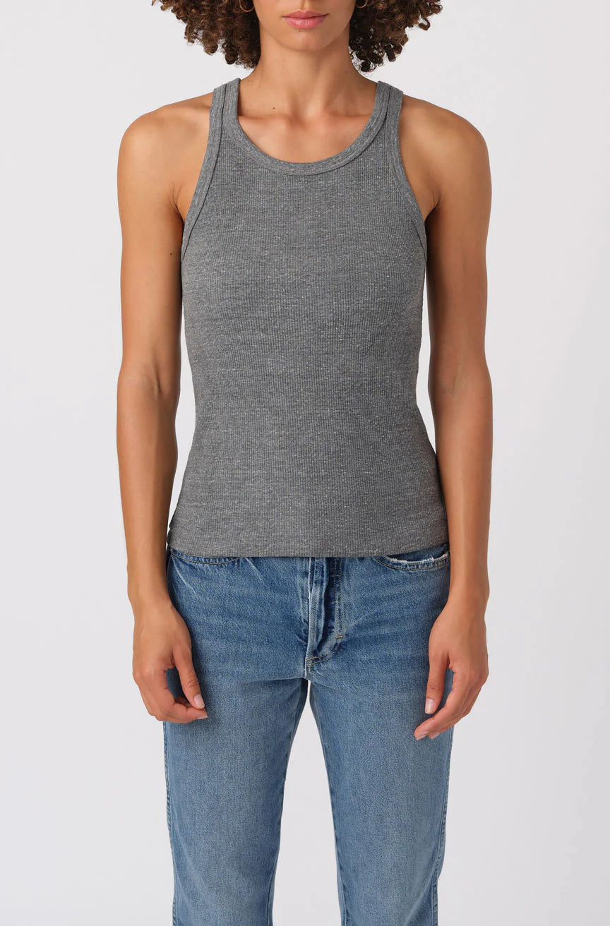 Person wearing a gray tank top and blue jeans on a white background