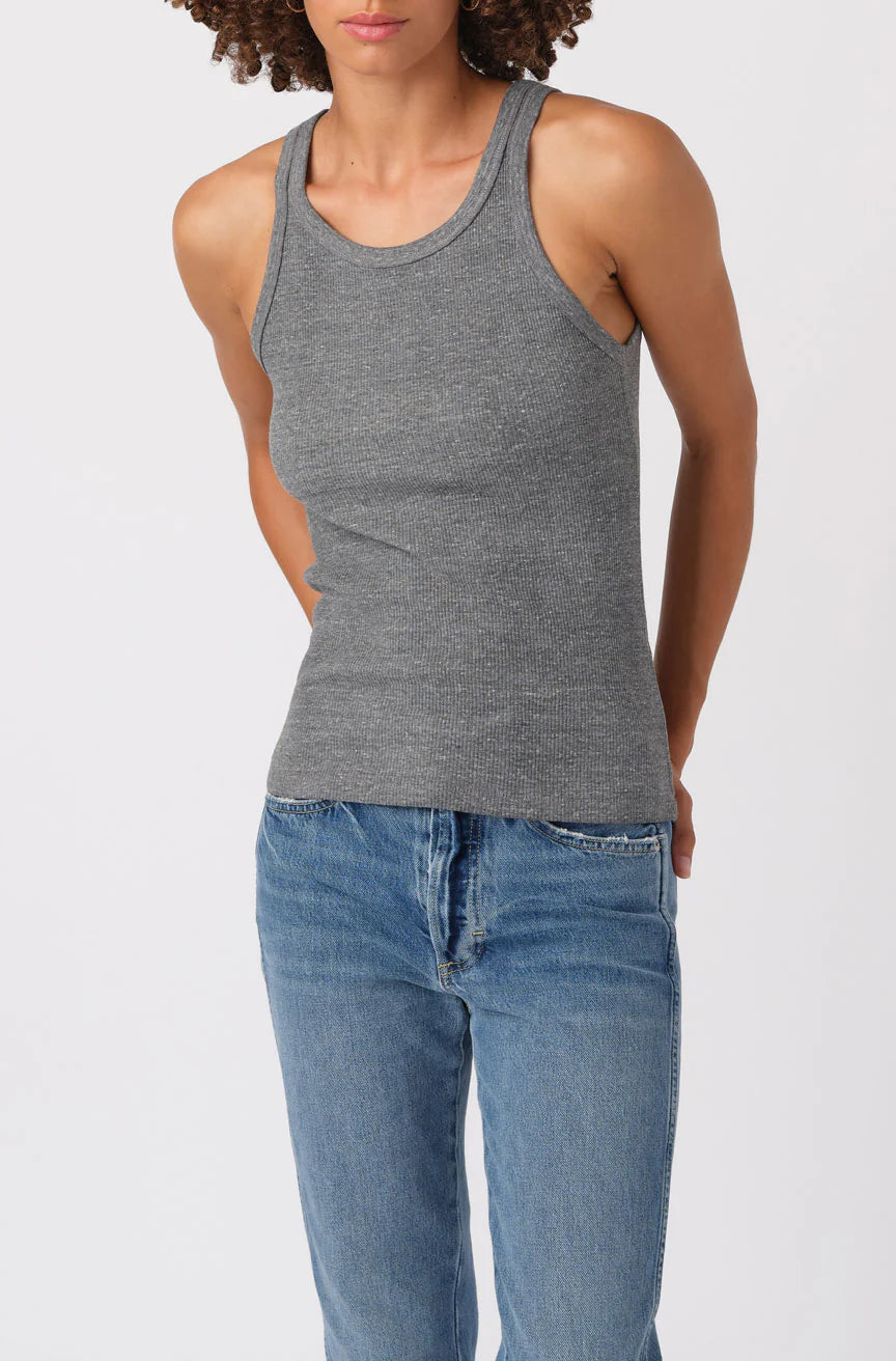 Person wearing a gray tank top and blue jeans on a white background