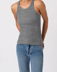 Person wearing a gray tank top and blue jeans on a white background