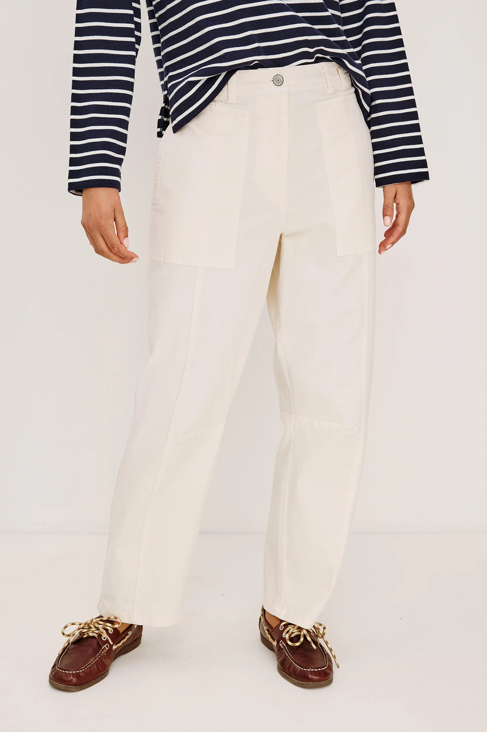 Person wearing a striped shirt, white pants, and brown loafers on a white background