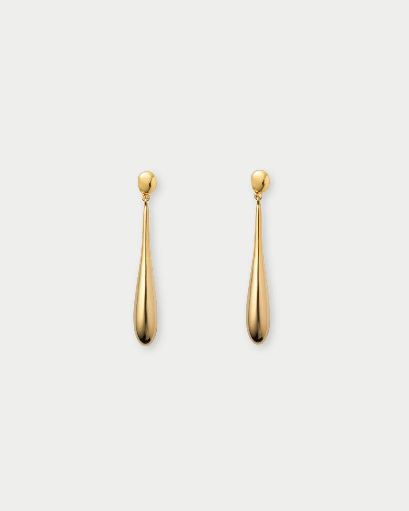 A pair of gold dangle earrings with a teardrop-shaped drop and a small round stud at the top, shown against a light gray background.