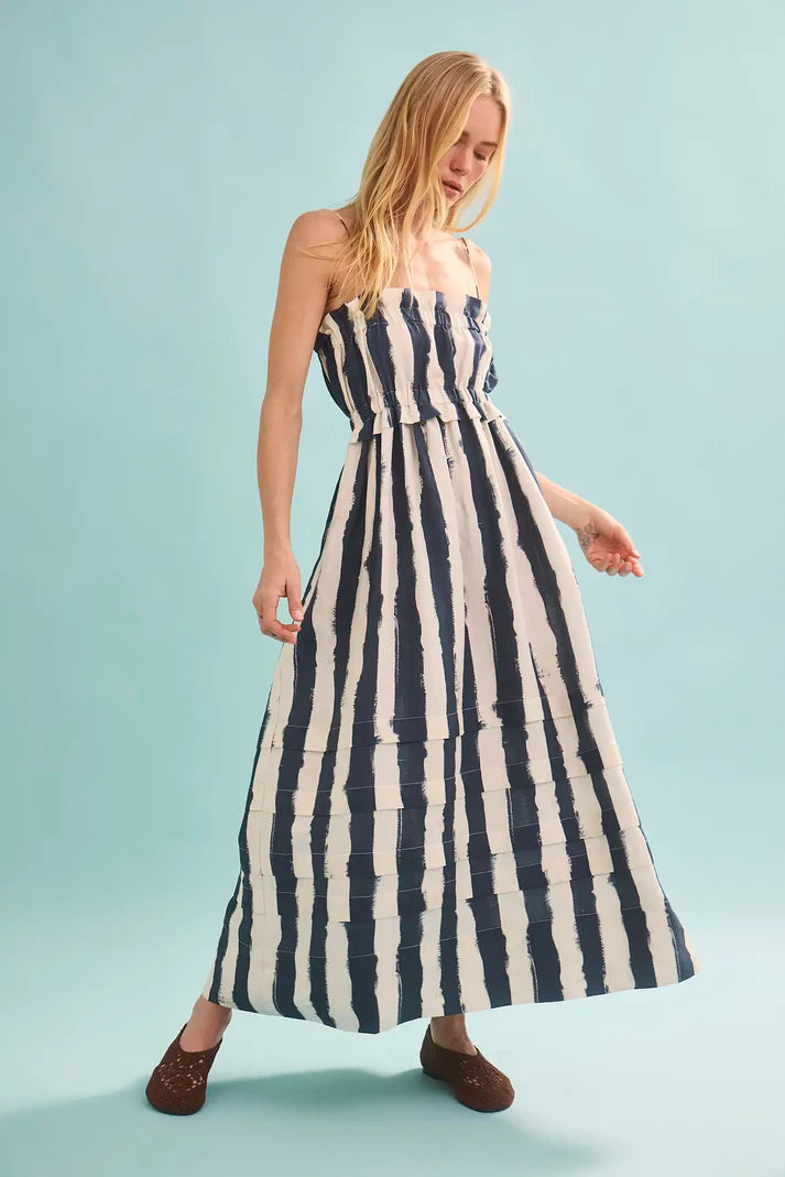 Woman wearing a blue and white striped dress on a light blue background