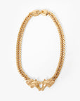 Gold chain necklace with a unique clasp design on a white background