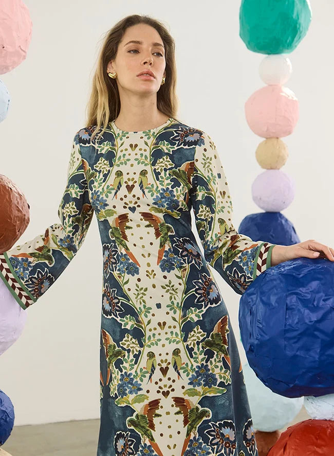 model wearing a print dress with art balls around her and a white background