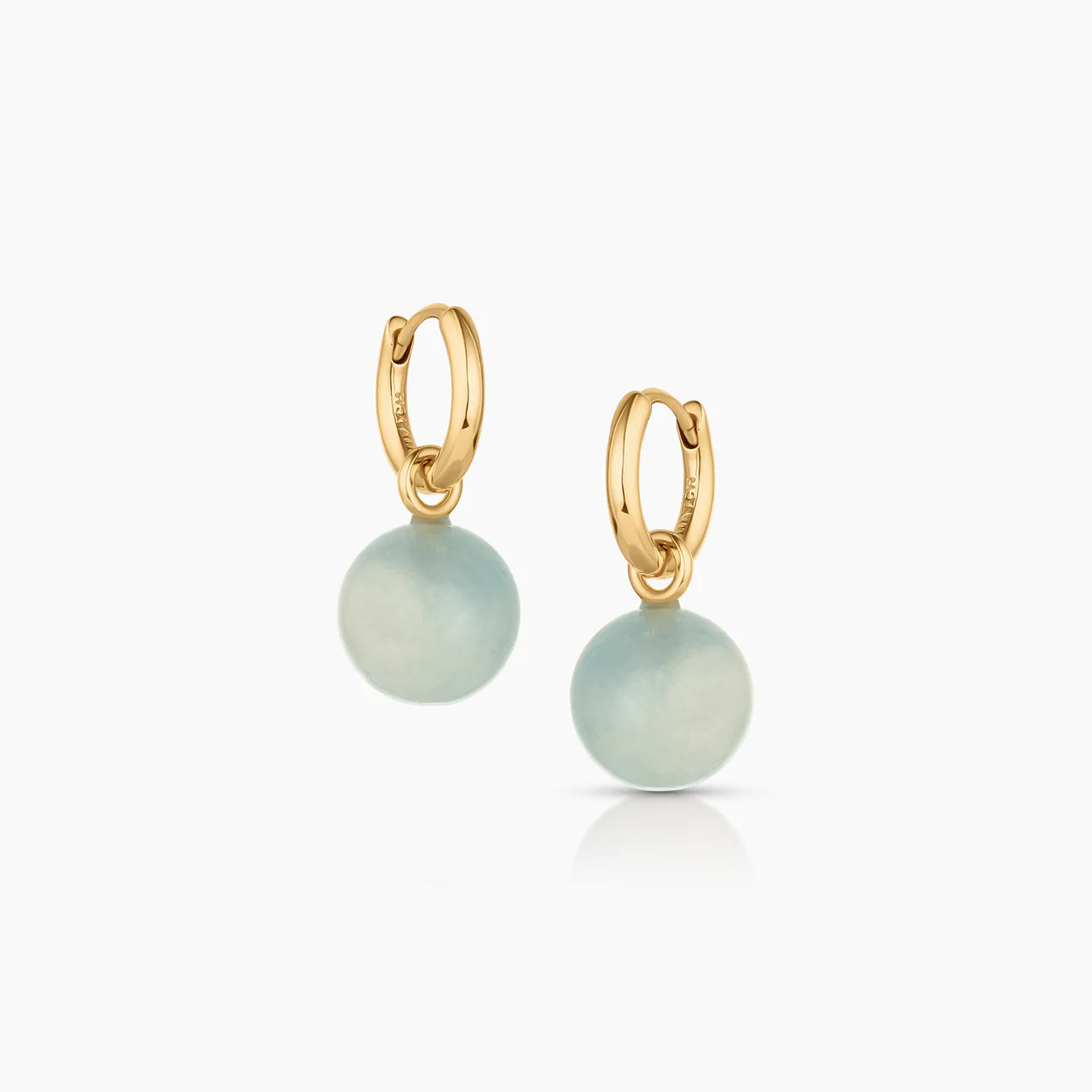 Gold hoop earrings with aquamarine round stones on a white background