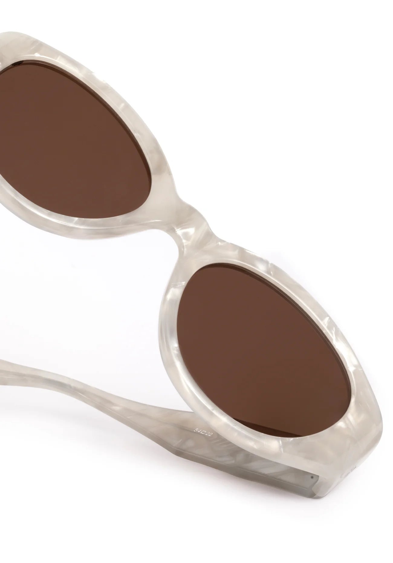 Sunglasses with brown lenses and a white frame on a white background