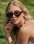 Woman with average, heart face shape wearing Lucy Venezia Sunglasses in a grassy outdoor setting