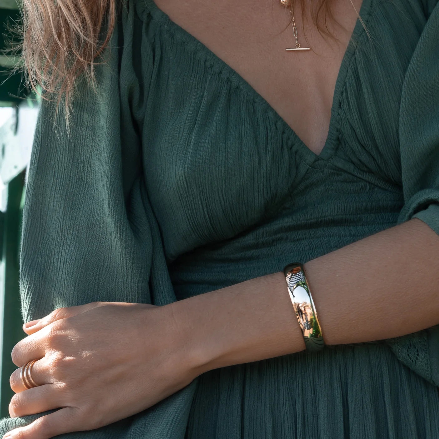 Lumi Cuff Bracelet in Gold front view on model in green dress