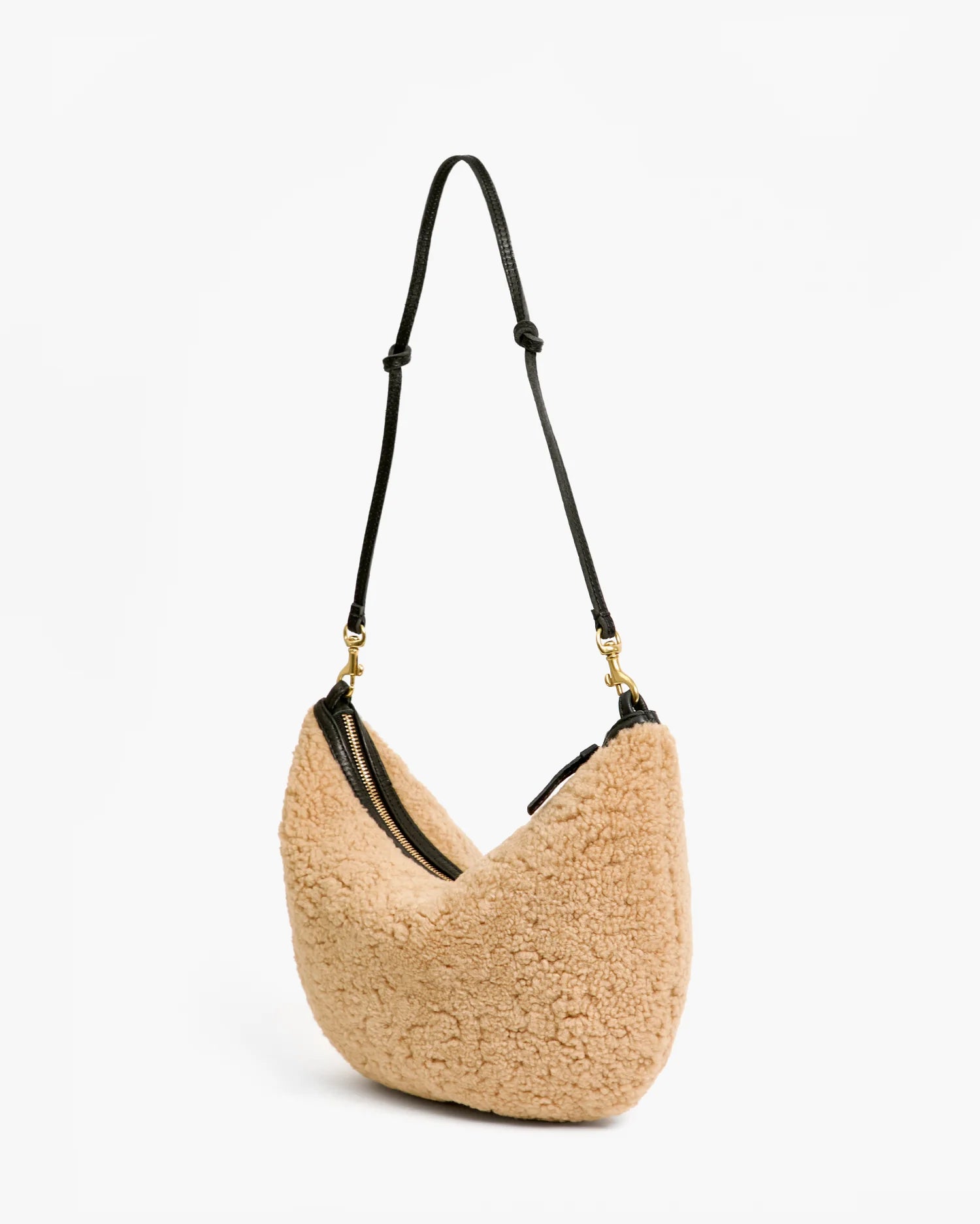 Beige handbag with black strap on a white background