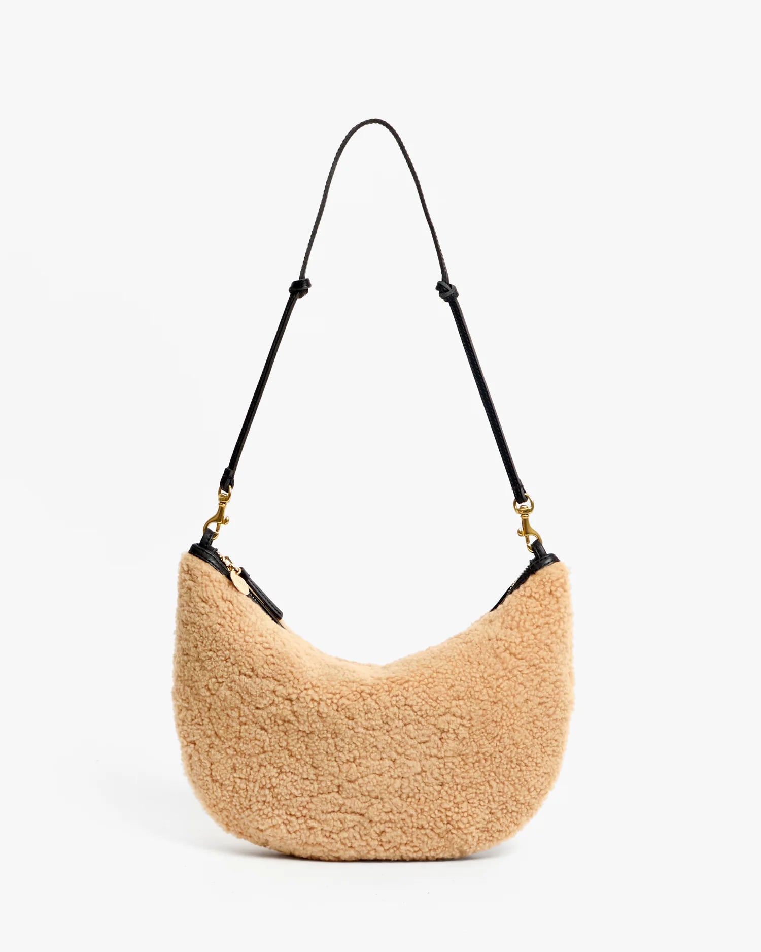 Beige handbag with black strap on a white background