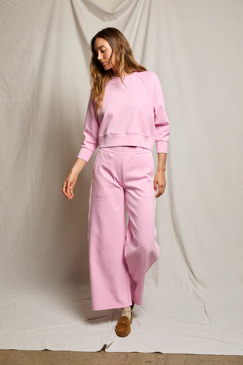 Woman wearing a pink outfit against a plain background