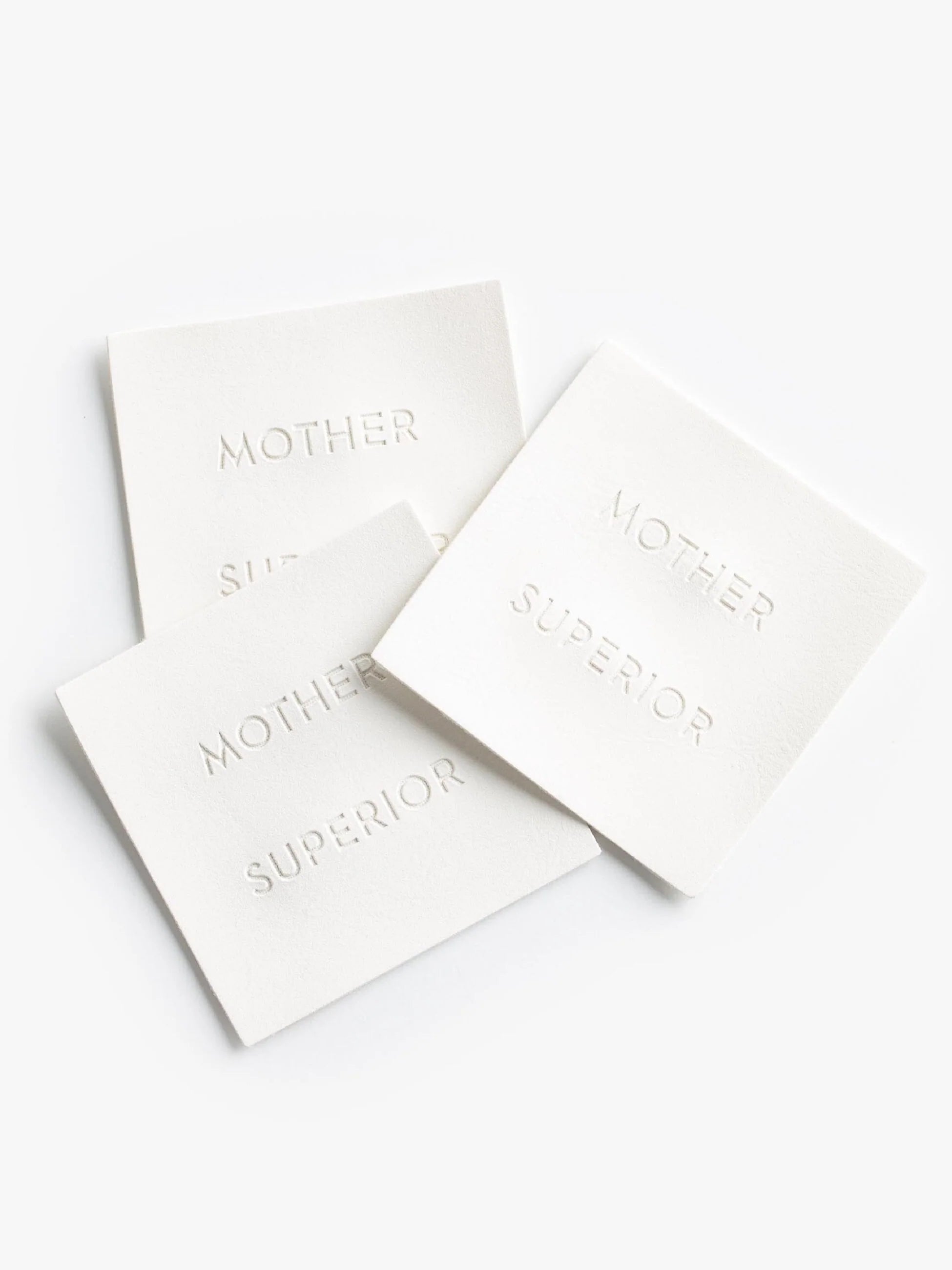 Three white labels with &#39;MOTHER SUPERIOR&#39; text on a white background