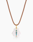 Necklace with a white pendant featuring blue stones on a white background