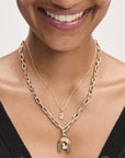 Woman wearing gold necklaces with a pendants and beads