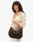 Woman holding a leopard print handbag against a white background
