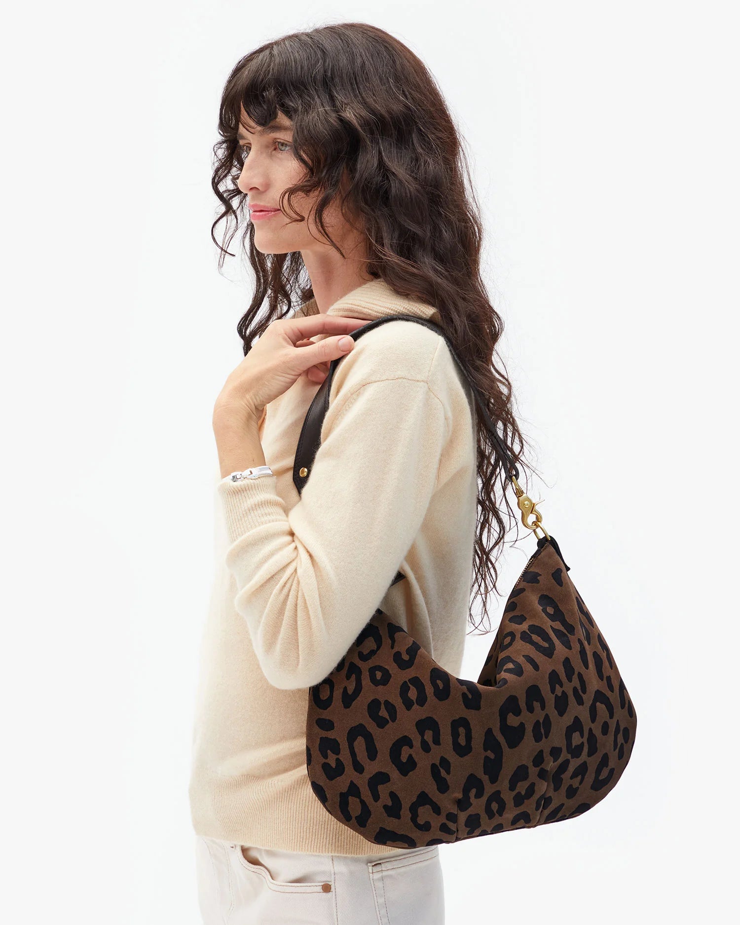 Woman holding a leopard print handbag against a white background