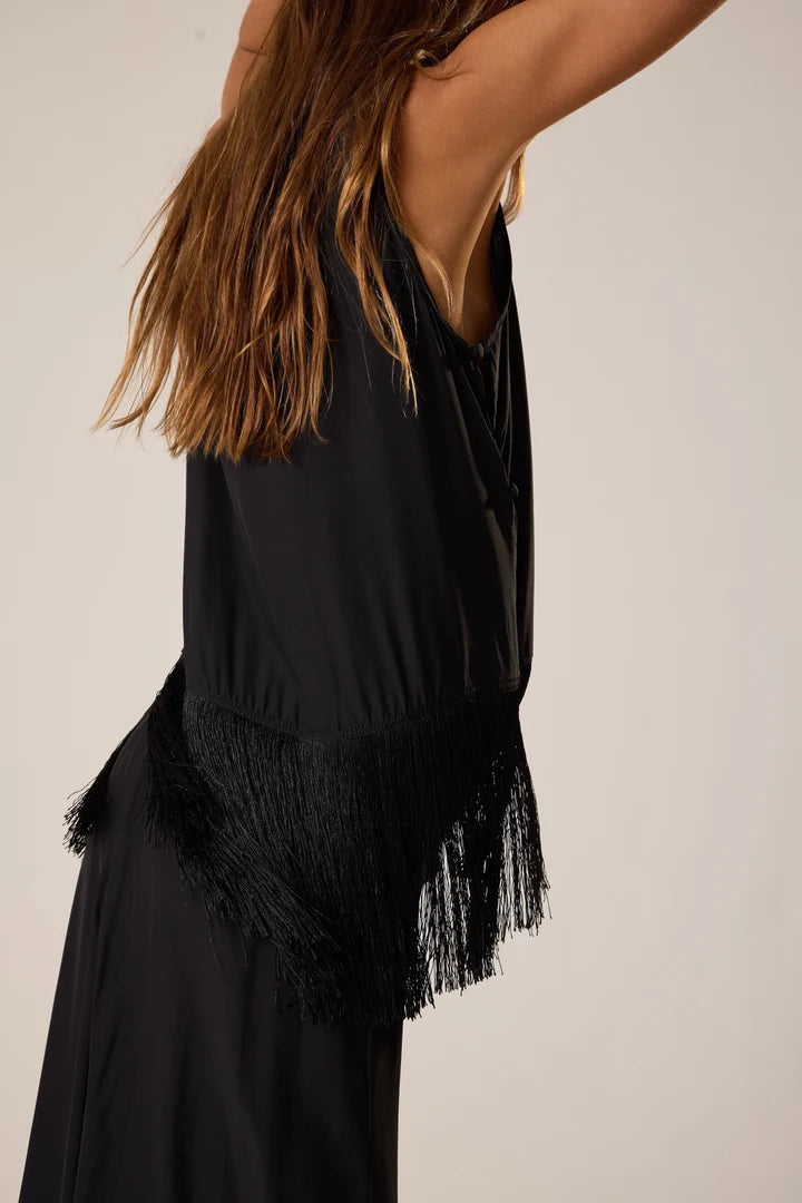 Black fringe top worn by a person on a neutral background