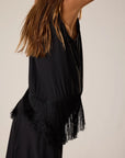 Black fringe top worn by a person on a neutral background
