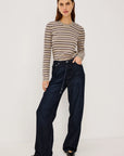 denim tie waist pant worn by a model with a stripe shirt on a grey background