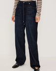 denim tie waist pant worn by a model with a stripe shirt on a grey background
