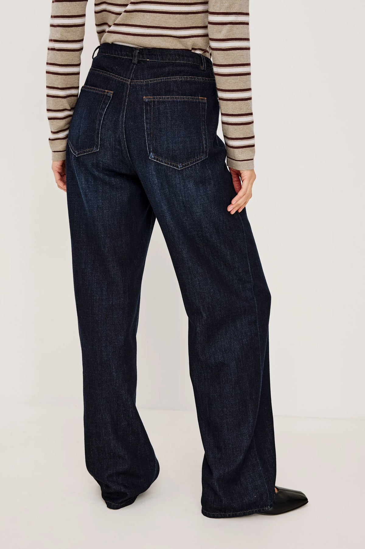 denim tie waist pant worn by a model with a stripe shirt on a grey background, back