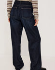 denim tie waist pant worn by a model with a stripe shirt on a grey background, back