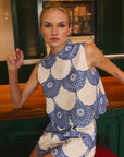 Woman wearing a blue and white patterned matching set sitting in a restaurant.