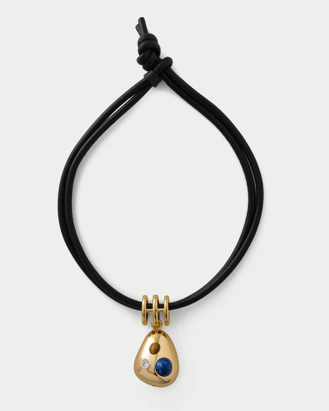 Black cord necklace with a gold pendant featuring a blue gemstone on a white background