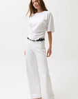 Woman wearing a white t-shirt and white pants on a white background