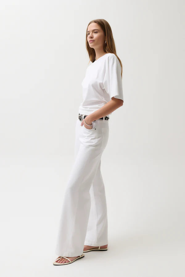 Woman wearing a white t-shirt and white pants on a white background