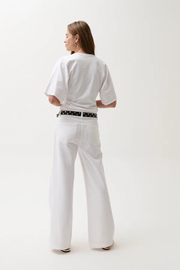 Person wearing a white outfit with a belt on a plain background