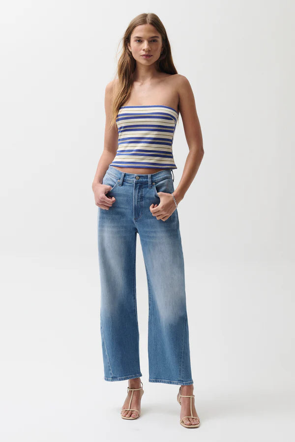 Woman wearing a striped top and blue jeans on a white background