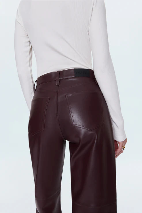 Brown leather pants worn by a person on a light blue background back view