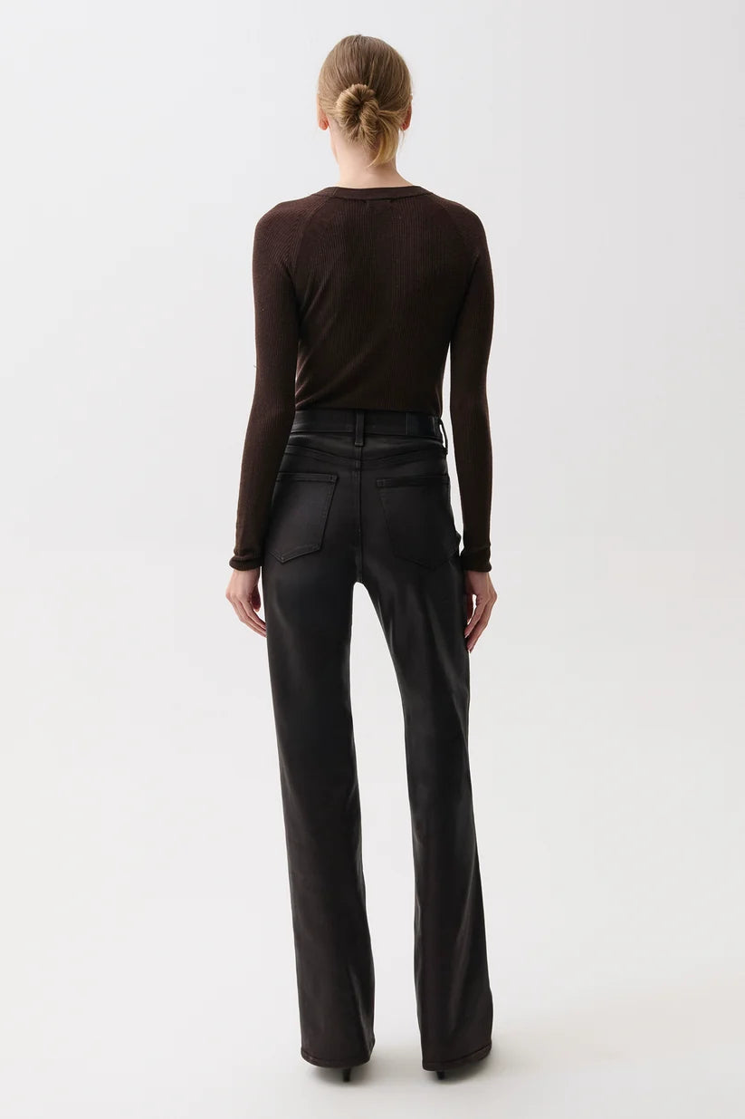 A model viewed from the back wearing a dark brown long-sleeve top and black wide-leg trousers, standing against a plain white studio background.