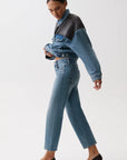 Woman wearing a denim outfit with a white background