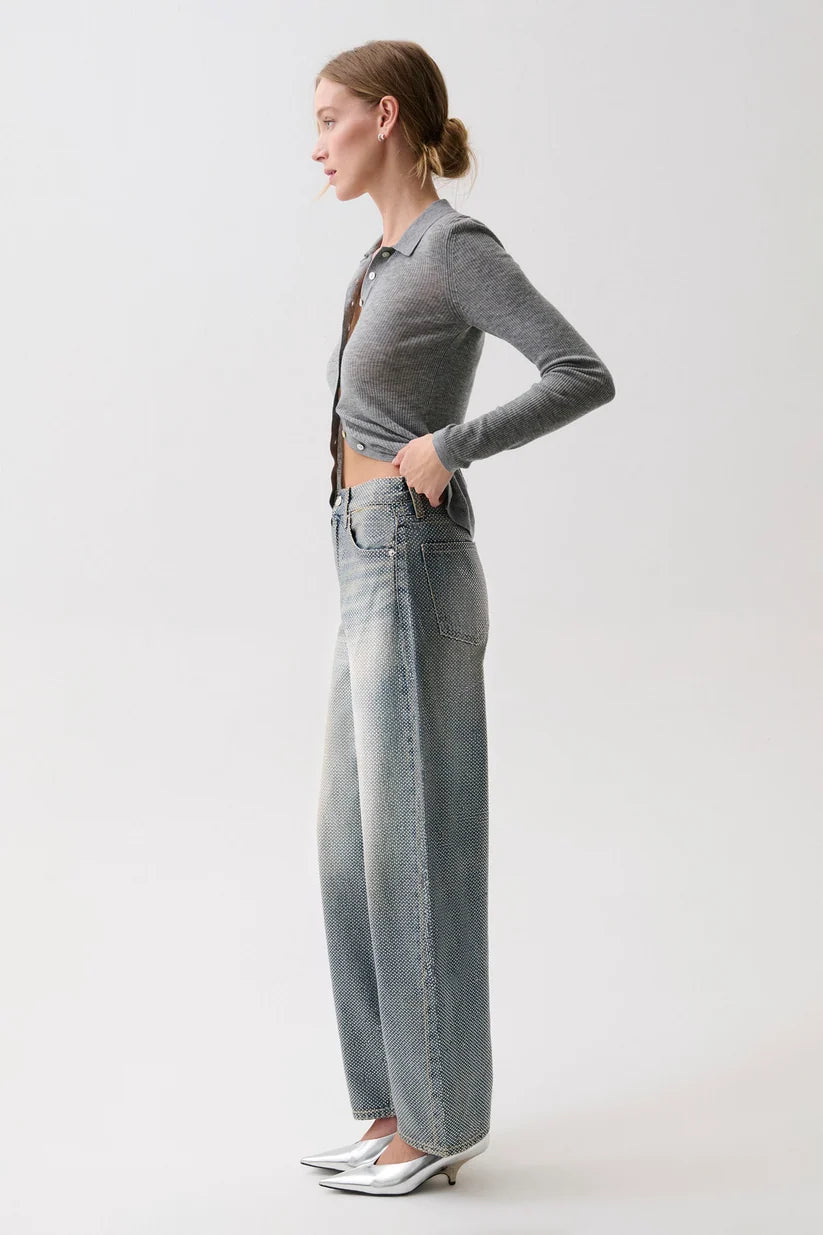 model wearing a rhinestone blue jean with a long sleeve grey top on a white background, side view